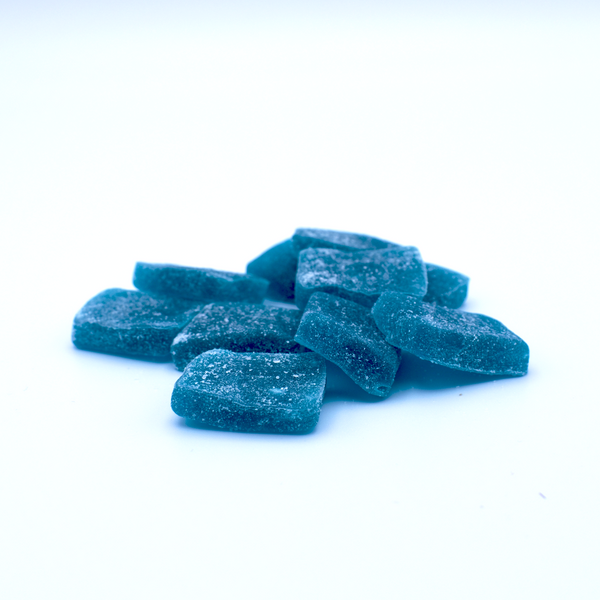 A pile of blue razz flavored kratom gummies is on a white background.