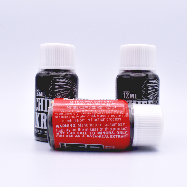 Three 12ML bottles of Chief Kratom Shots are on a white background. Two bottles with black labels are in the back. A bottle with a red label lays on its side in front of it. The text on its side lists information about the contents of the shot.